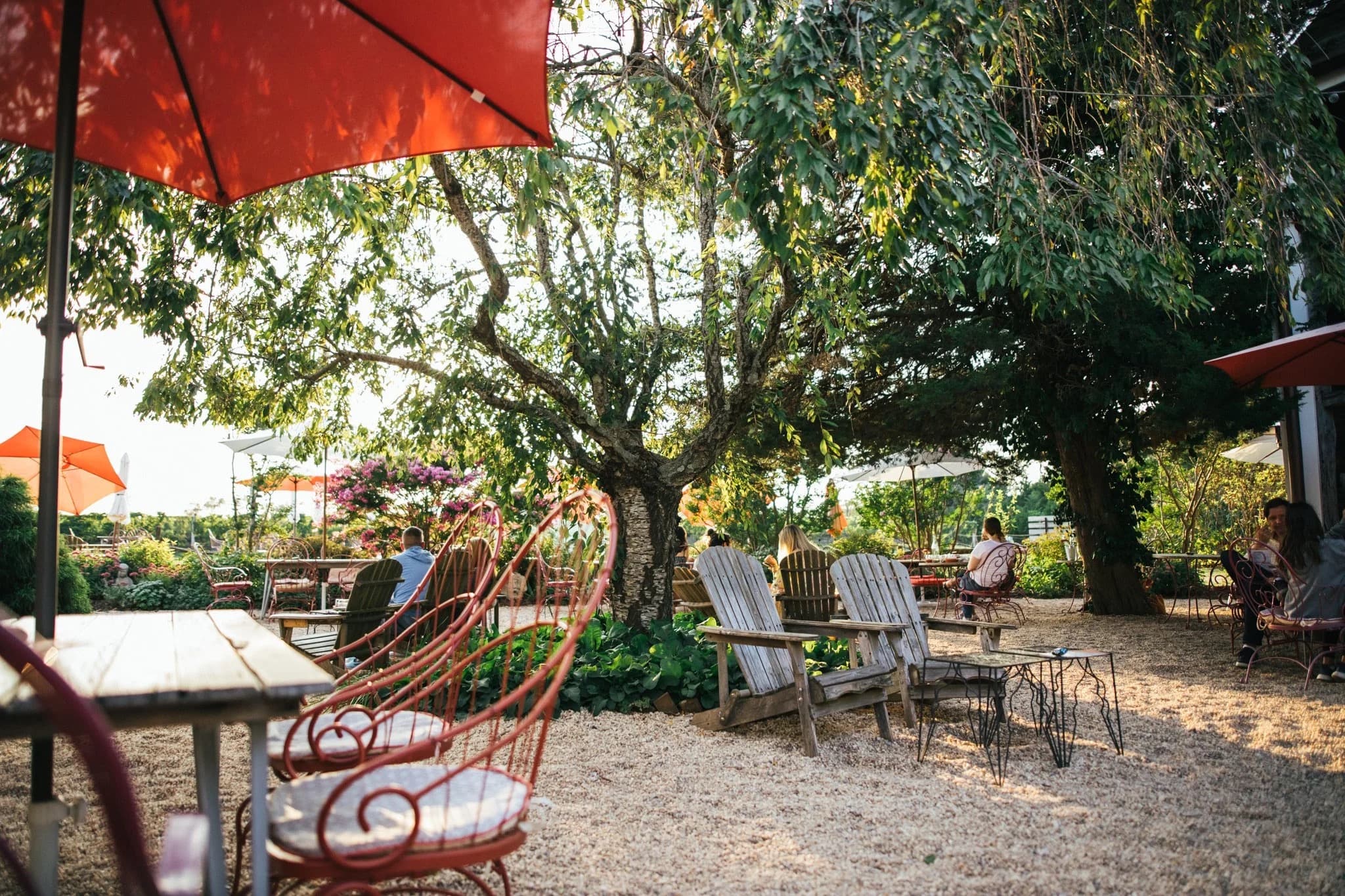 Shaded gravel garden with orange umbrellas at Croteaux Vineyards in Southold