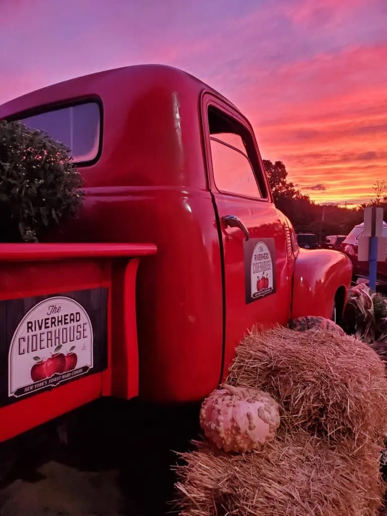 Vintage red pickup, hay bales and pumpkins at Riverhead Ciderhouse